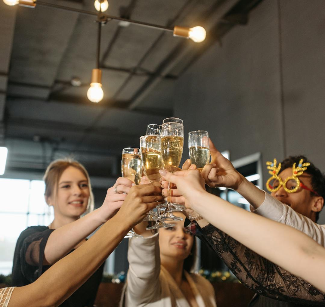 Guests raising champagne glasses at a celebration.