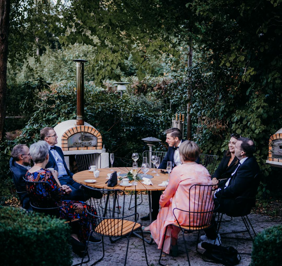 Guests gathered around a garden dinner table.